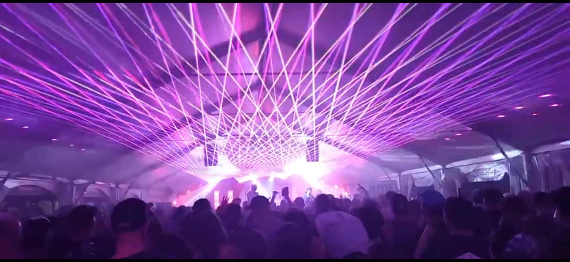 Packed crowd under stage lights at a Coastal Productions night show