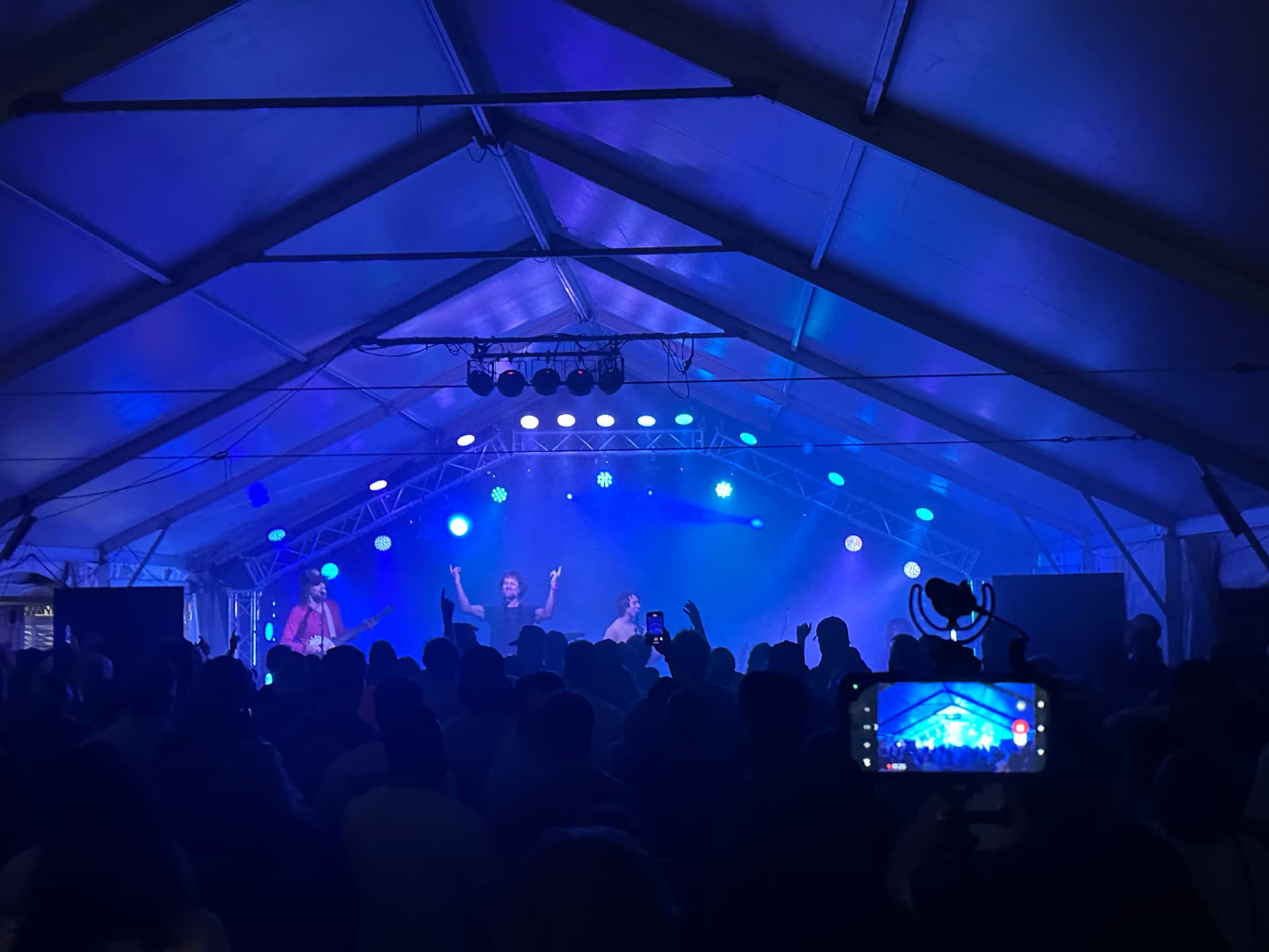Chadwick Stokes performing under a custom truss arch in blue concert lighting